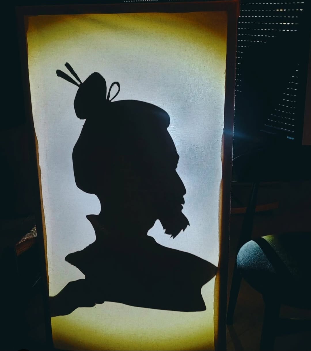 Silhouette en ombre chinoise projetée dans un cadre lumineux &mdash; spectacle Yuki et le secret du Renard